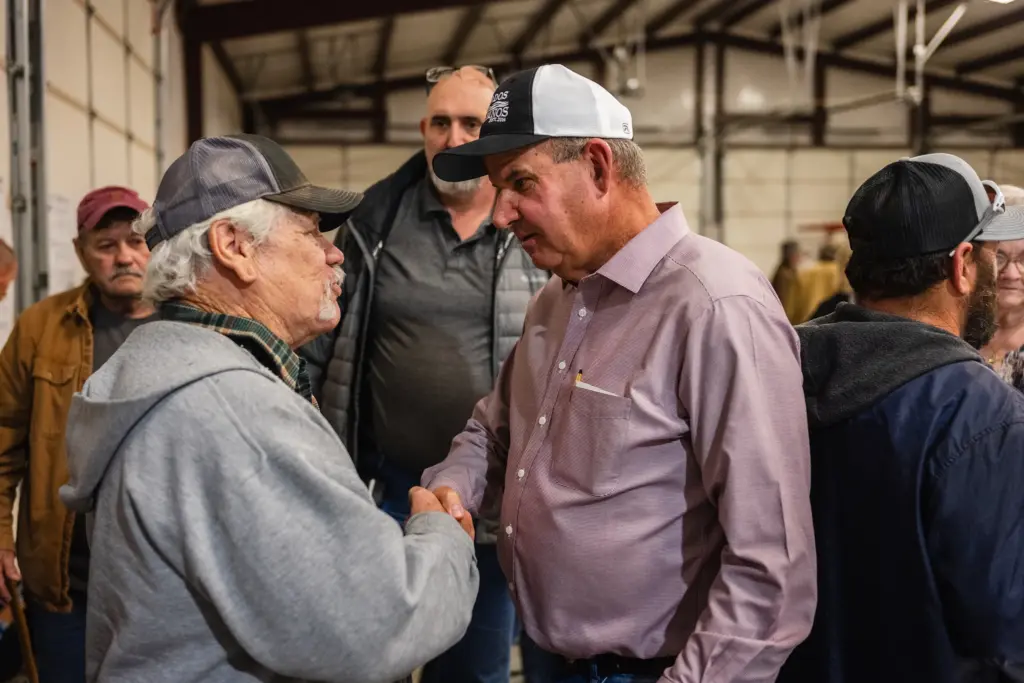 State representative Pat Curry shakes the hand of a constituent during a community meeting in opposition to the proposed Infrakey data center in Ross, Texas, on Dec. 7, 2025.