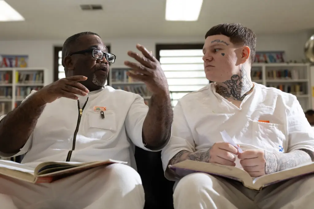 Freeman Arthur Brown, left, and Carroll Trent Dodson talk as they read through GED prep books in the library at the Wynne Unit in Huntsville.