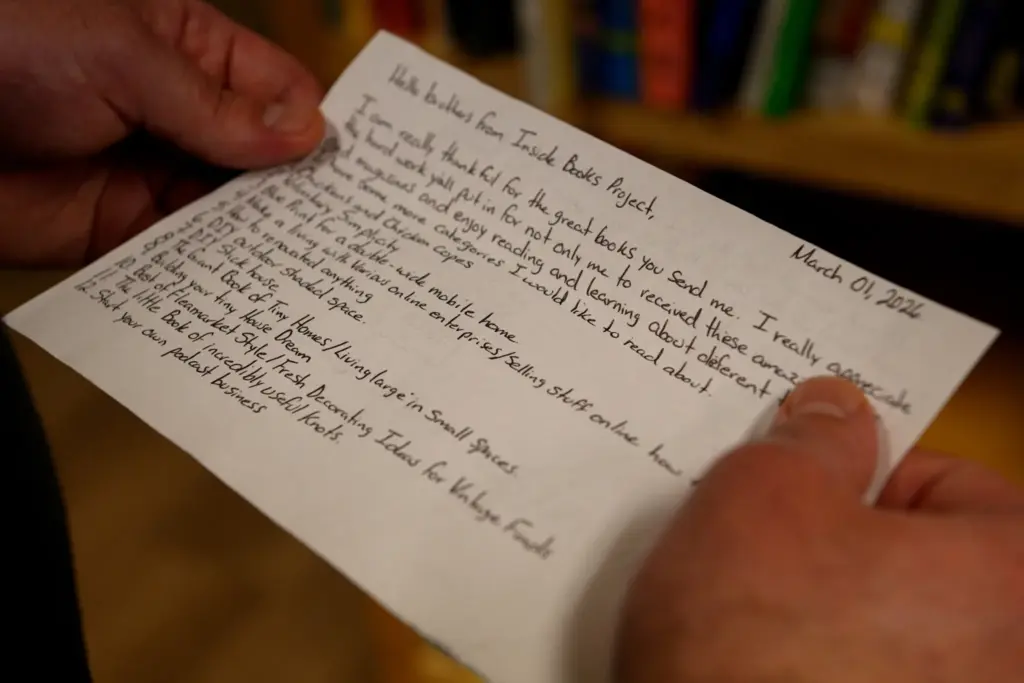 A volunteer with Inside Project Books reads a letter from an incarcerated person following a TDJC ban on hardcover books over fears that they could be used to ferry in contraband.