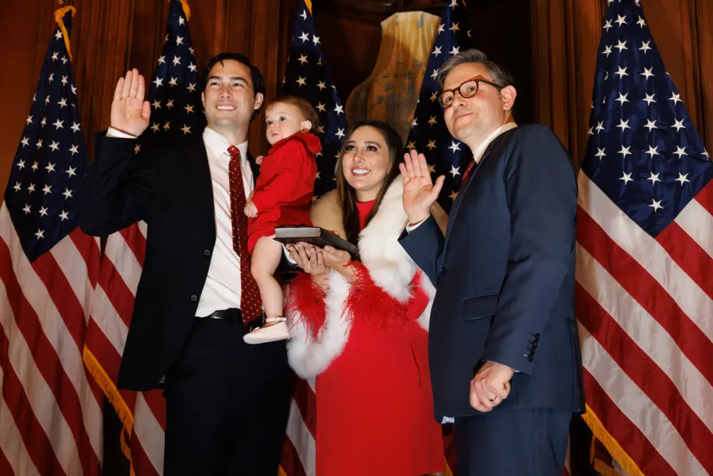 U.S. Rep. Brandon Gill and his family, including wife Danielle D'Souza Gill, pose with Mike Johnson in the Rayburn Room of the Capitol Building in Washington, D.C. during the opening of the 119th Congress. D'Souza Gill is the daughter of right-wing commentator Dinesh D'Souza, who is Indian.