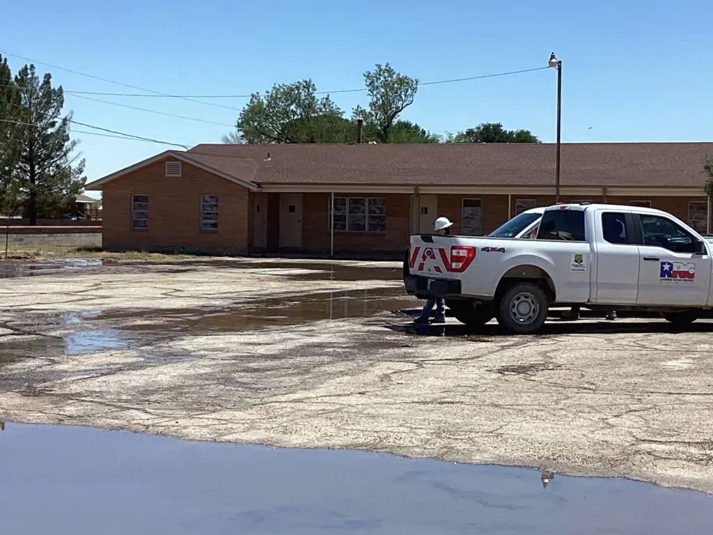 Water pools at the First Baptist Church of Grandfalls on April 21 while a Railroad Commission staff member looks on.