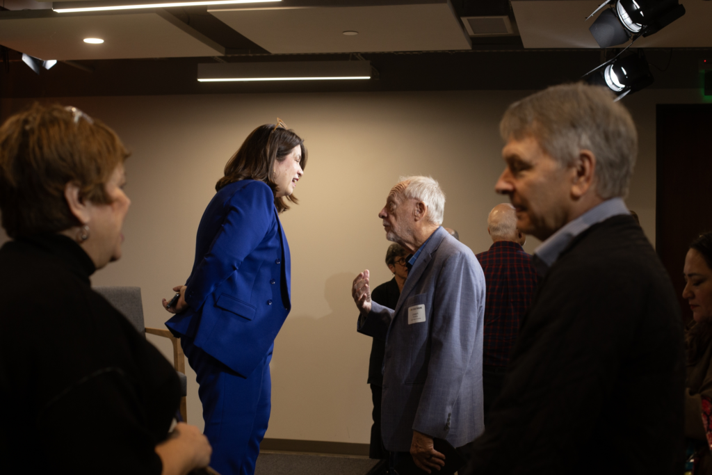 An attendee speaks with a panelist on Jan. 21, 2025, following a discussion on how the Dementia Prevention and Research Institute of Texas can help make the state a research leader.