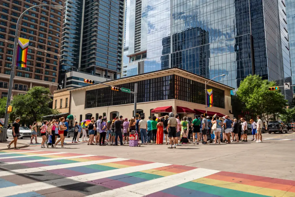 People gather around the newly installed mural on 4th street on June 20, 2026 in downtown Austin. The new mural sits near the rainbow crosswalk, which the city of Austin plans to scrap off by the end of July.