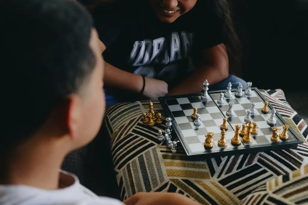 Y aged 10 and 14, play chess with each other at their home on June 27, 2026. The girl pictured learned to play chess while she and her brother were held in ORR custody for 400 days after trying to enter Texas from Honduras.