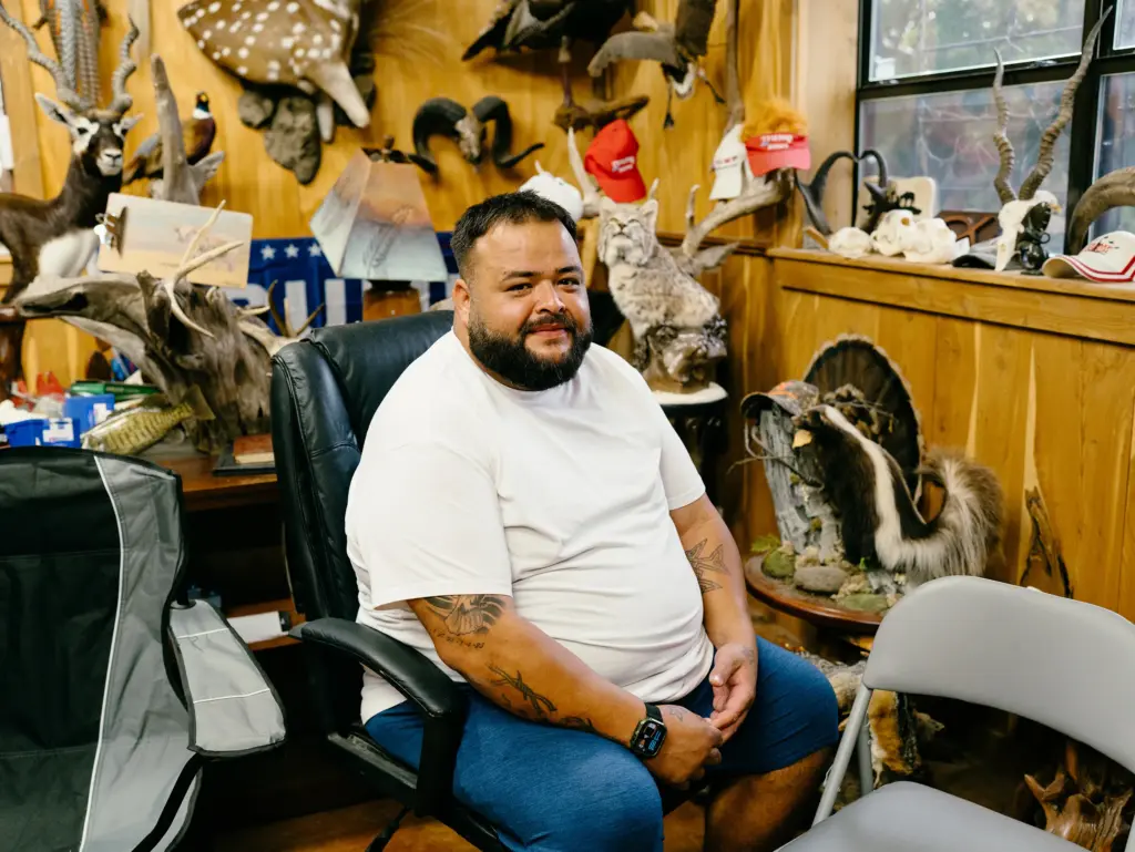Joseph Rounsley sits for a portrait in the showroom of Jet’s Taxidermy Supply, where he works, in Kerrville, Texas on June 12, 2026. Rounsley lost his brother Julian Ryan in the Kerr County flood on July 4, 2025.