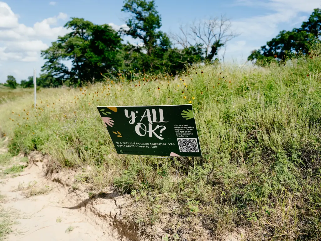 A sign on the side of the road in Center Point offers resources for flood relief.