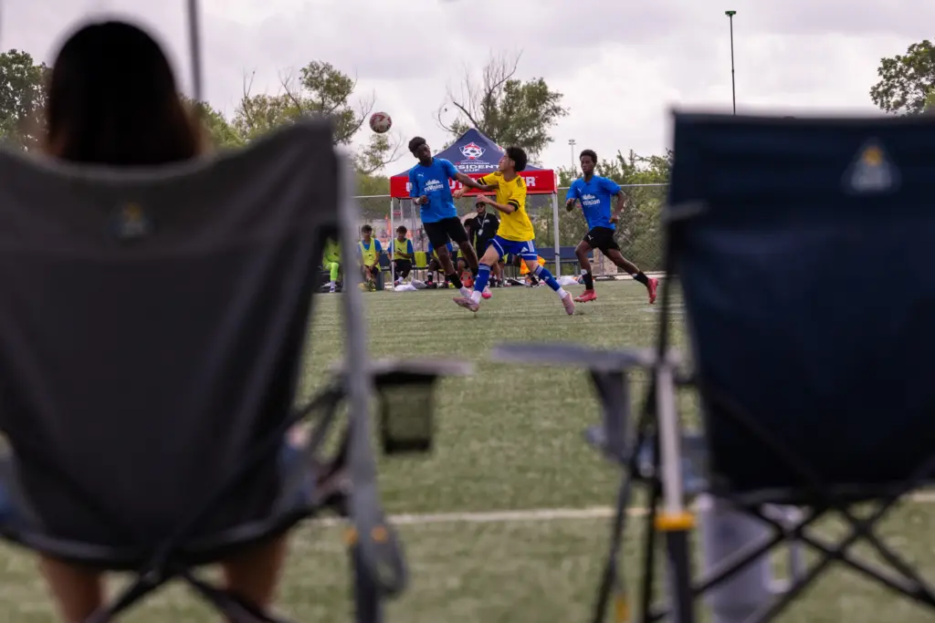 Kinyinga Mbala, at center, wins a header during the regional final of the US Youth Soccer Presidents Cup, on June 14, 2026, in Round Rock. (Antranik Tavitian for The Texas Tribune)