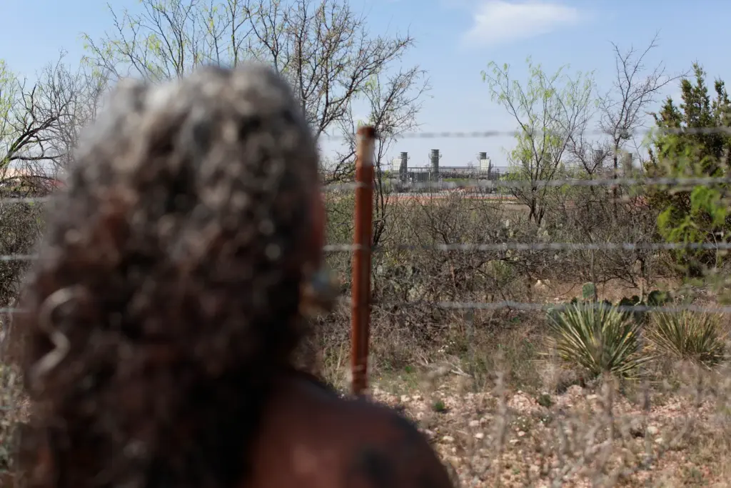Omaira Garcia stands at her property line bordering OpenAI’s flagship “Stargate” data center in Abilene, Texas. The data center’s gas-fueled power plant is located roughly 500 yards from her home.