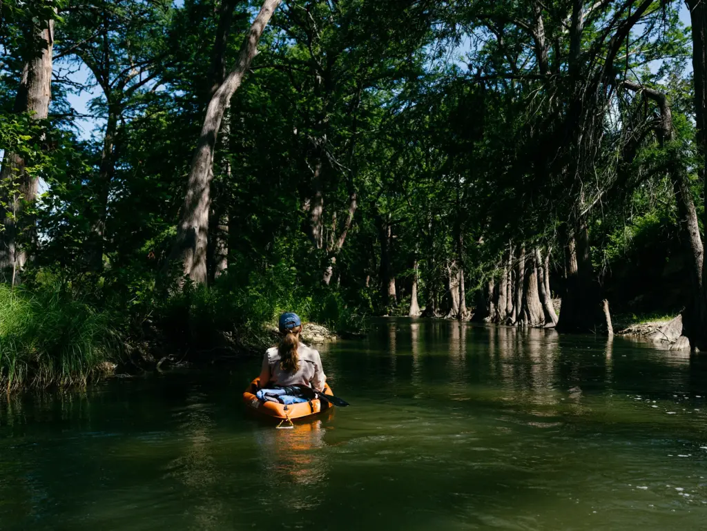 Texas Tribune reporter Emily Foxhall takes notes on a kayak on the Guadalupe River in Center Point, Texas on June 13, 2026.