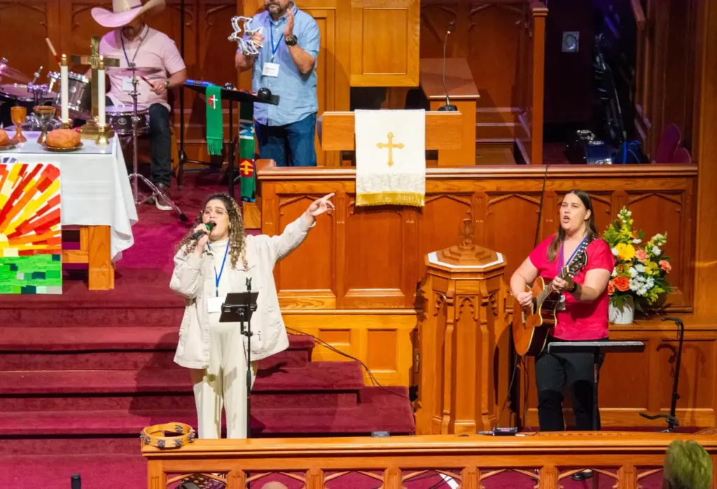 The Rev. Rosedanny Ortiz, left, sings during a worship service.