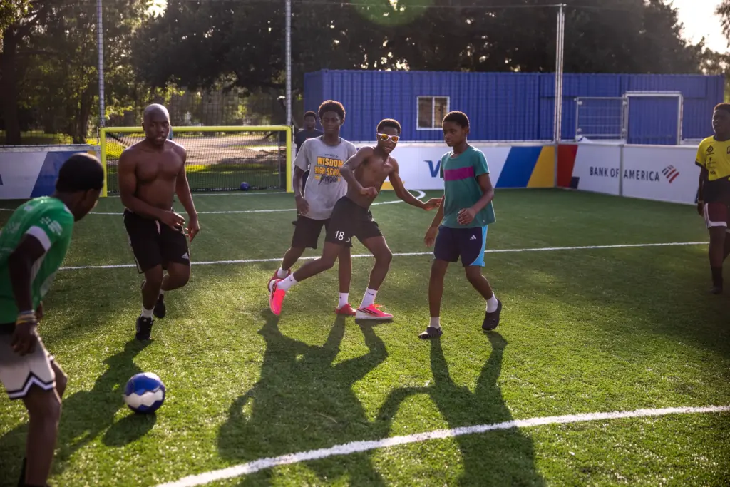 Moises Badera, center, follows the ball during a soccer match with friends in late June.