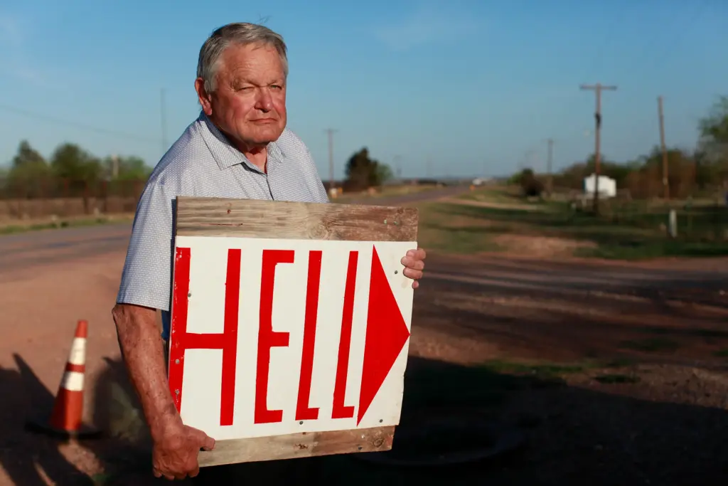 Paul Daniel, 81, lives directly beside OpenAI’s “Stargate” data center. Like his neighbor, Omaira Garcia, Daniel says he was never informed of the project until it was too late to leave. He made this sign and placed it on the road leading to Stargate’s entrance. “It just kind of ruined our area,” Daniel says.