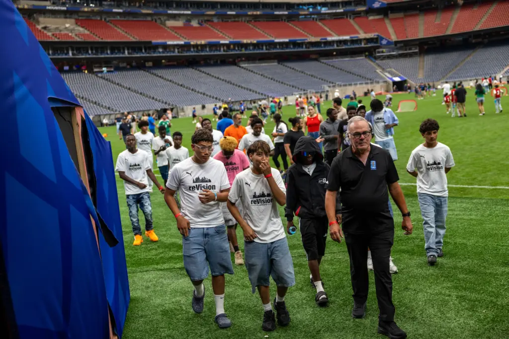 Charles Rotramel, founder of Houston reVision, leads the team off the field as they tour the World Cup stadium in early July.