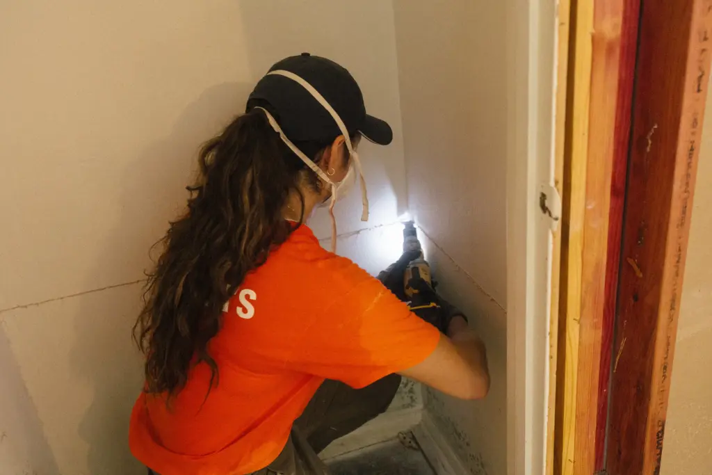 Larissa Giron, a volunteer with Samaritan’s Purse, removes drywall with mold from water damage inside a home from the July 16 flood in Kerrville, Texas on July 28, 2026.