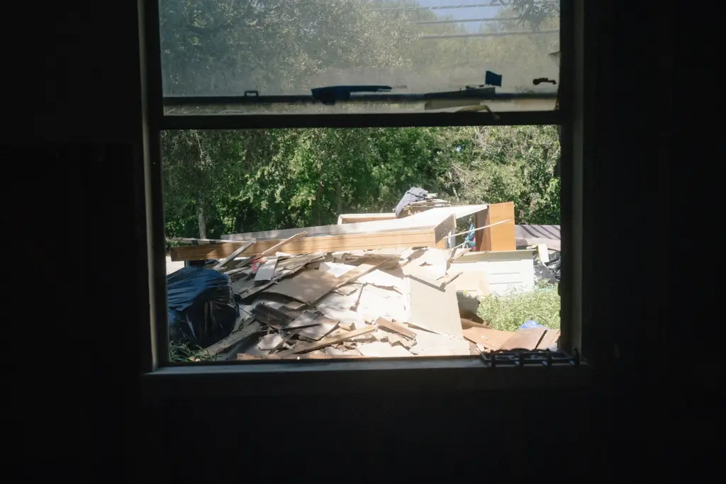 Furniture and other items from Michael Ybarra’s home that were damaged by the July 16 flood seen through a window in his home in Kerrville, Texas on July 28, 2026.