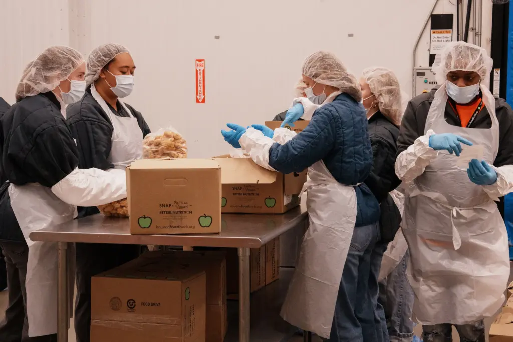 Volunteers sort and prepare food in the protein pack room at Houston Food Bank in Houston on Aug. 12, 2026.